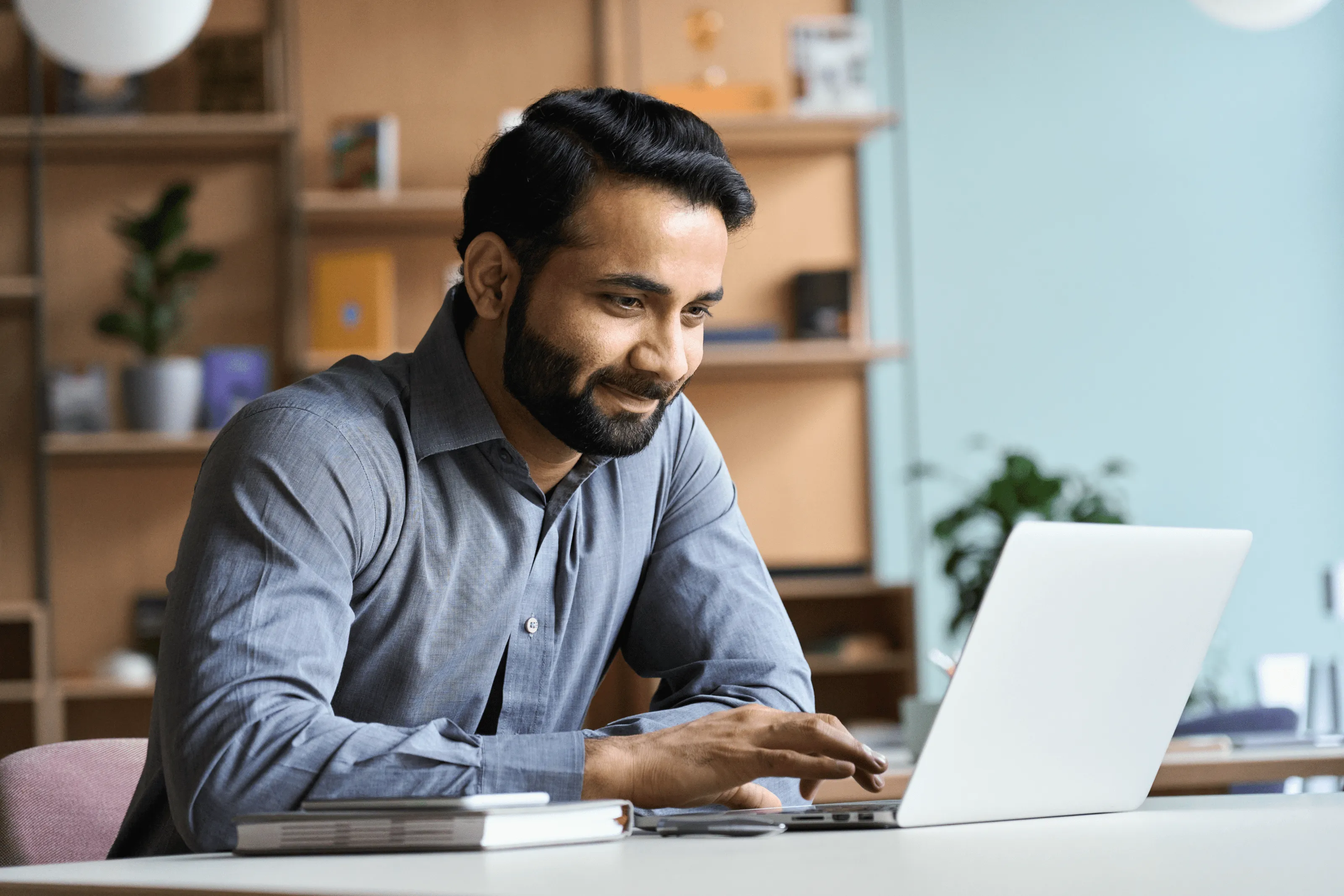 Man with beard smiling at laptop